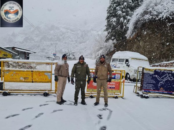 policemen guarding the barrier at hanuman chatti during heavy snow